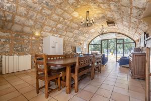 a dining room with a table and a stone wall at Finca Sa Mina Family in El Port de la Selva
