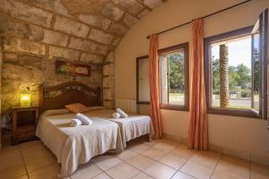 a bedroom with two beds and two windows at Finca Sa Mina Family in El Port de la Selva