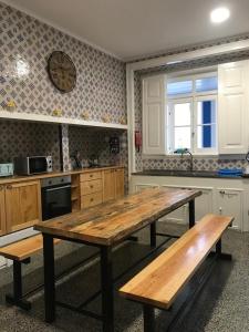 a kitchen with a wooden table and two benches at Nerinha Residence in Coruche