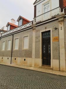 a building with a black door on a street at Nerinha Residence in Coruche