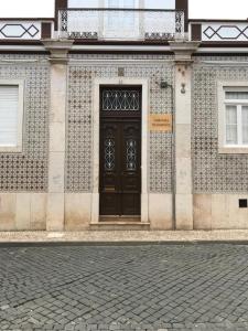 un edificio con una puerta negra a un lado. en Nerinha Residence, en Coruche