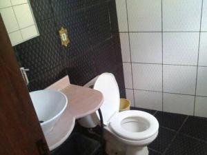 um banheiro com um vaso sanitário branco e uma pia em Raízes de Afrodite quartos em São Thomé das Letras mais 4 fotografias