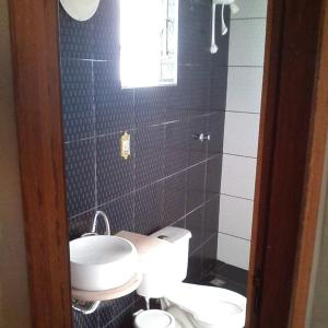 um pequeno banheiro com um vaso sanitário e uma pia em Raízes de Afrodite quartos em São Thomé das Letras