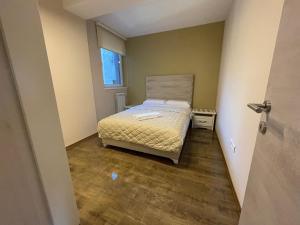 a small bedroom with a bed and a window at Roosevelt Apartment in Skopje +5 photos