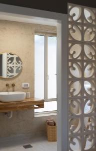 a bathroom with a sink and a mirror and a window at סיני 48 מלון דירות בוטיק in Vered Yeriho
