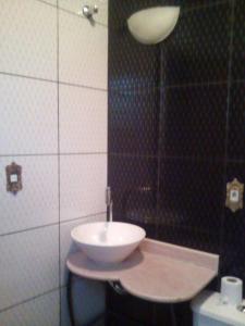 um banheiro com pia e vaso sanitário em Raízes de Afrodite quartos em São Thomé das Letras