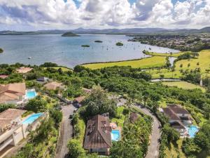 una vista aérea de un complejo con una masa de agua en Villa Caluma, magnifique villa de 3 chambres avec piscine et vue mer, accès rapide au golf, Trois ilets, en Les Trois-Îlets