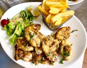 a plate of food with french fries and broccoli at Auberge Le Beaulieu -Cantal in Beaulieu