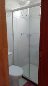 a bathroom with a toilet and a glass shower at Apartamento Praia dos Milionários 3 Quartos e Ar condicionado in Ilhéus