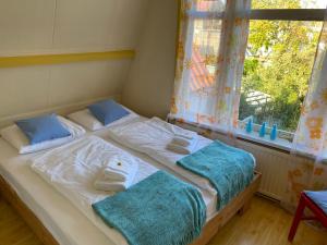 een slaapkamer met 2 bedden, handdoeken en een raam bij Zierikzee Appartement ZZ 41 B&B in Zierikzee