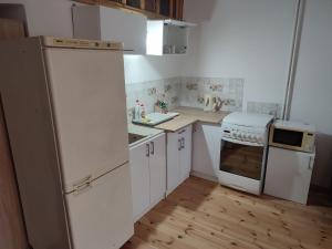 a kitchen with white appliances and a wooden floor at Łapu Capu - Mieszkanie dla 4 osób in Grajewo