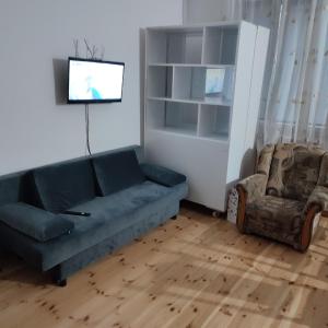 a living room with a couch and a chair at Łapu Capu - Mieszkanie dla 4 osób in Grajewo