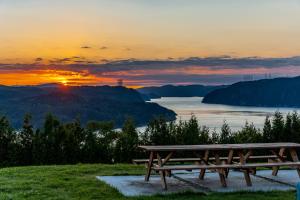 una mesa de picnic frente a un lago al atardecer en MontFJORD - Chalets, vue spectaculaire et SPA. ChantaFJORD #4, en Sacré-Coeur