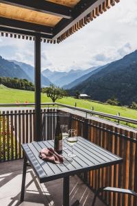 a picnic table with a bottle of wine on a deck at Tante Anna Apartments in Sankt Gallenkirch