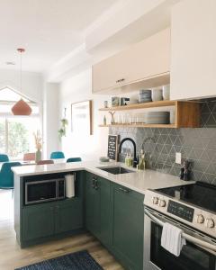 a kitchen with green cabinets and a sink at Mount Rundle Hideaway with Heated Pool & Hot Tub and allows Pets in Canmore