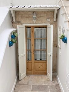 eine Holztür in einem Flur mit zwei Pflanzen in der Unterkunft La casa di Alessia Largo Torre in Noci