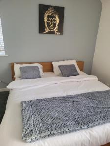 阿什頓安德萊恩的住宿－NO 7 Decent Home (Generous luxury bedroom)，墙上有两张照片的房间