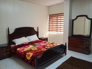 ein Schlafzimmer mit einem Bett mit einer Kommode und einem Spiegel in der Unterkunft Ibbin hospitality house in Adschlun