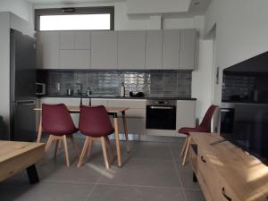 - une cuisine avec une table et des chaises rouges dans l'établissement Όμορφη οικία στο κέντρο της Σαλαμίνας., à Salamine