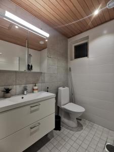 a white bathroom with a toilet and a sink at Apartment Beach & Golf Kalajoki in Kalajoki