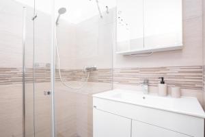 a white bathroom with a shower and a sink at Bright Apartment in Old Town by Prague Days in Prague