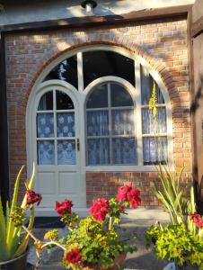 an arched door with flowers in front of a brick building at Helesfa Vendégház in Helesfa