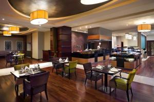 a restaurant with tables and chairs and a bar at Crowne Plaza Al Khobar by IHG in Al Khobar +61 photos