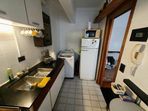 una pequeña cocina con fregadero y nevera. en Un Hogar en La Feliz en Mar del Plata