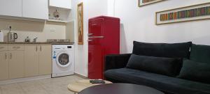 a living room with a couch and a red refrigerator at Next to the marina in Ashqelon