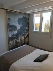 1 dormitorio con 1 cama y una gran pintura en la pared en Puytraud Mer, en Saint-Palais-sur-Mer