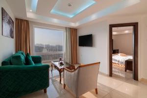 sala de estar con sofá verde y dormitorio en Petra Elite Hotel en Wadi Musa