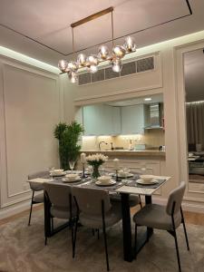 ein Esszimmer mit einem Tisch und Stühlen sowie eine Küche in der Unterkunft Beachfront Luxury Apartment-Pearl Island شقه مطله على الشاطئ بجزيرة اللؤلؤه in Doha