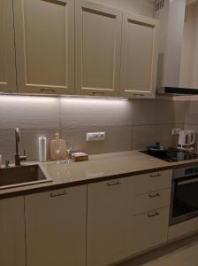 a kitchen with white cabinets and a sink at Lux apartment, near metro Vasylkivska in Kyiv