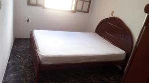 a bed in a room with a white mattress at Raízes de Afrodite Kitnet in São Thomé das Letras