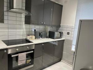 a kitchen with a sink and a microwave at Luxurious 2-Bed Apartment in Woolwich London in London