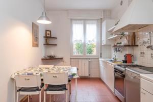 [Mimmi Apartment] Zurigo 12 في ميلانو: مطبخ مع طاولة وكراسي ومغسلة