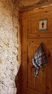 uma porta de madeira com uma toalha preta e branca em Muhra em Siwa