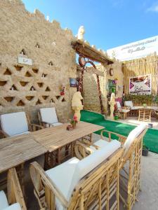 a patio with a wooden table and chairs at Muhra in Siwa