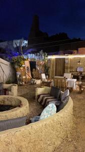 a patio with couches and a fire pit at night at Muhra in Siwa