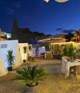 a group of tents with palm trees and a table at Muhra in Siwa