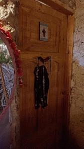 a wooden door with a bag hanging on a wall at Muhra in Siwa