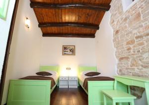 two beds in a room with a stone wall at VILLA GINA in Valtura