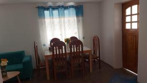 a dining room with a table and chairs and a window at Hospedaje Venka Urubamba in Urubamba