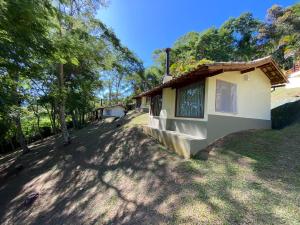 uma casa num quintal com árvores ao fundo em Chalés da montanha em Itaipava