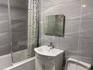 a bathroom with a sink and a toilet and a shower at Luxurious 2-Bed Apartment in Woolwich London in London