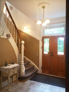 a hallway with a staircase and a wooden door at Awesome Foersum in Tarm