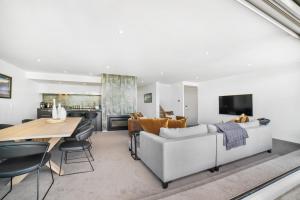 una sala de estar con un sofá y una mesa en Luxury Penthouse P2, en Queenstown
