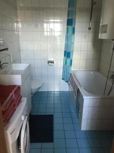 ein Badezimmer mit einer Badewanne, einem Waschbecken und einem WC in der Unterkunft Grazer Schwalbe in Graz