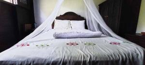 Una cama blanca con mosquitera. en Cabaña Velo de Novia, en Socoltenango