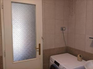 a bathroom with a door with a toilet and a window at Holiday Home Over The River in Bovec